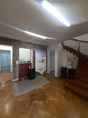 El mesón de recepción al entrar al centro, junto a la escalera de madera que sube al segundo piso.